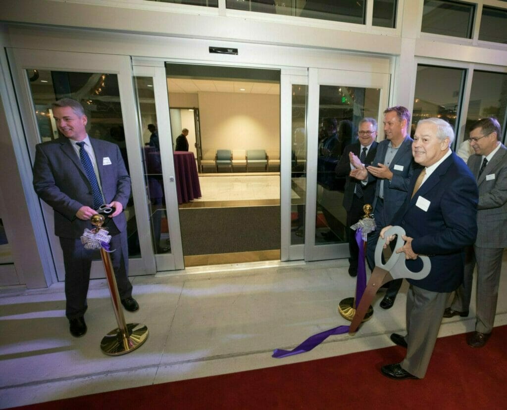 NexCore poses with abnormally large scissors for ribbon ceremony