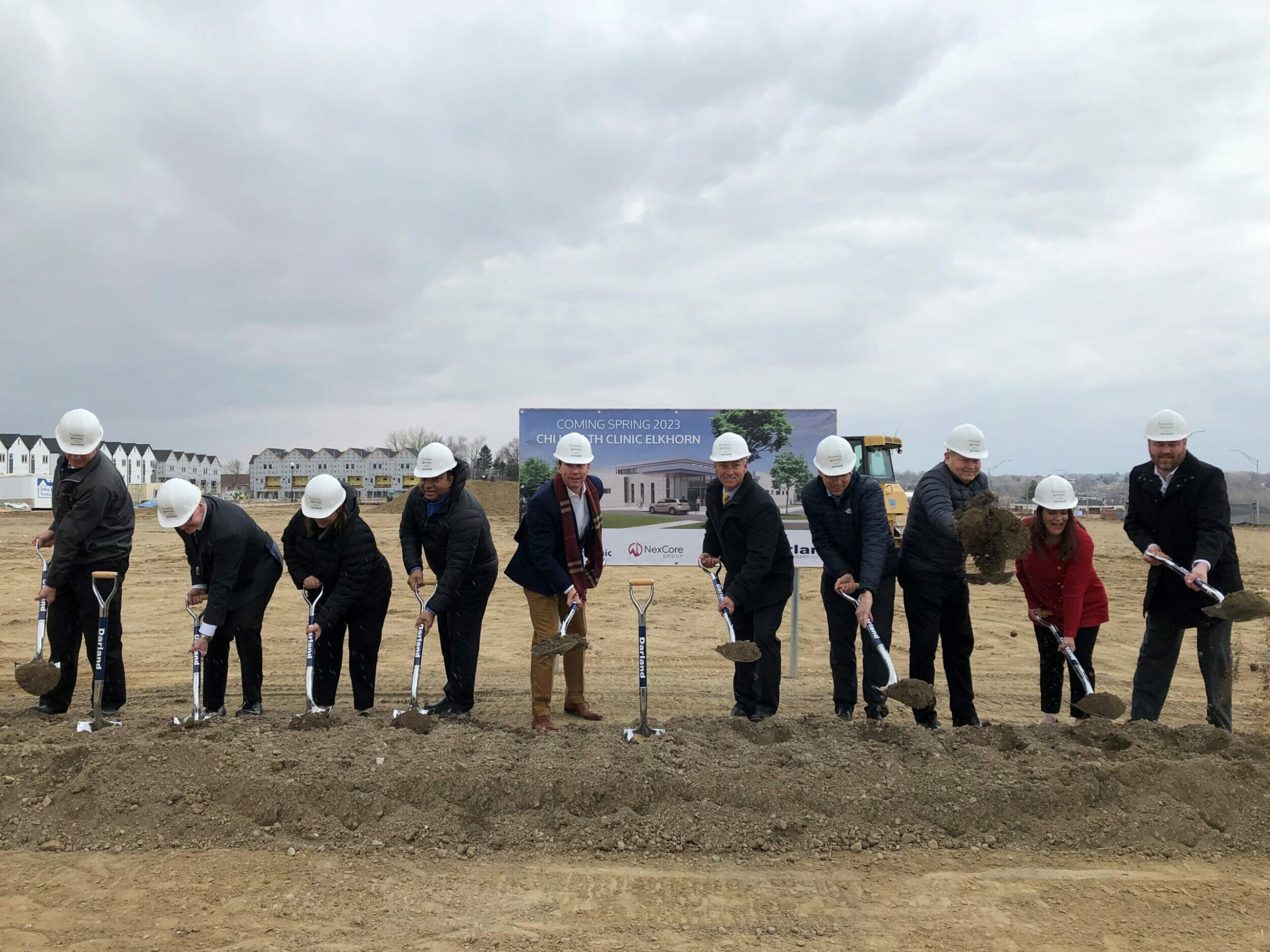 A group at a construction ground break ceremony holding shovels