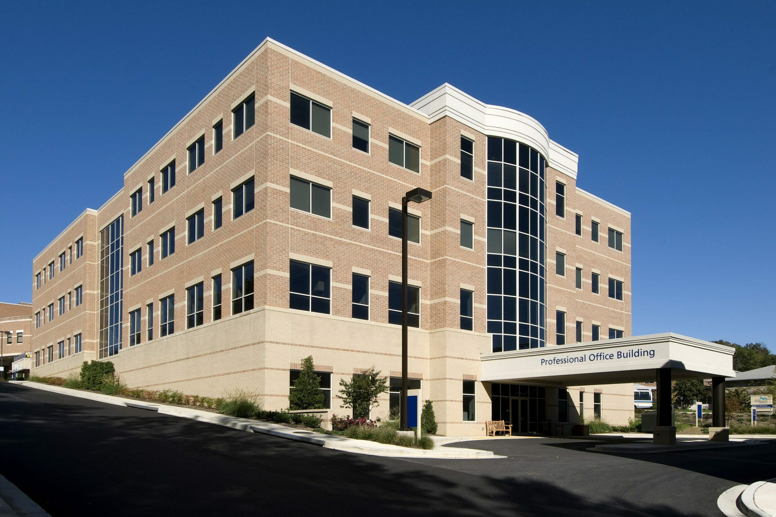 Exterior view professional office building, tan and red brick, blue sky