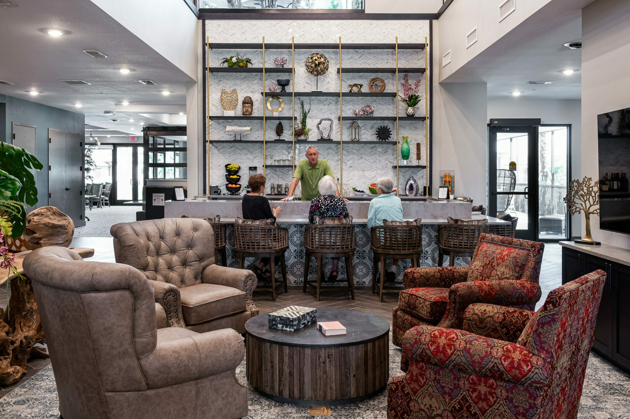 Lounge and bar area finished with wood, stone, and tile with women sitting at the bar chatting with the bartender