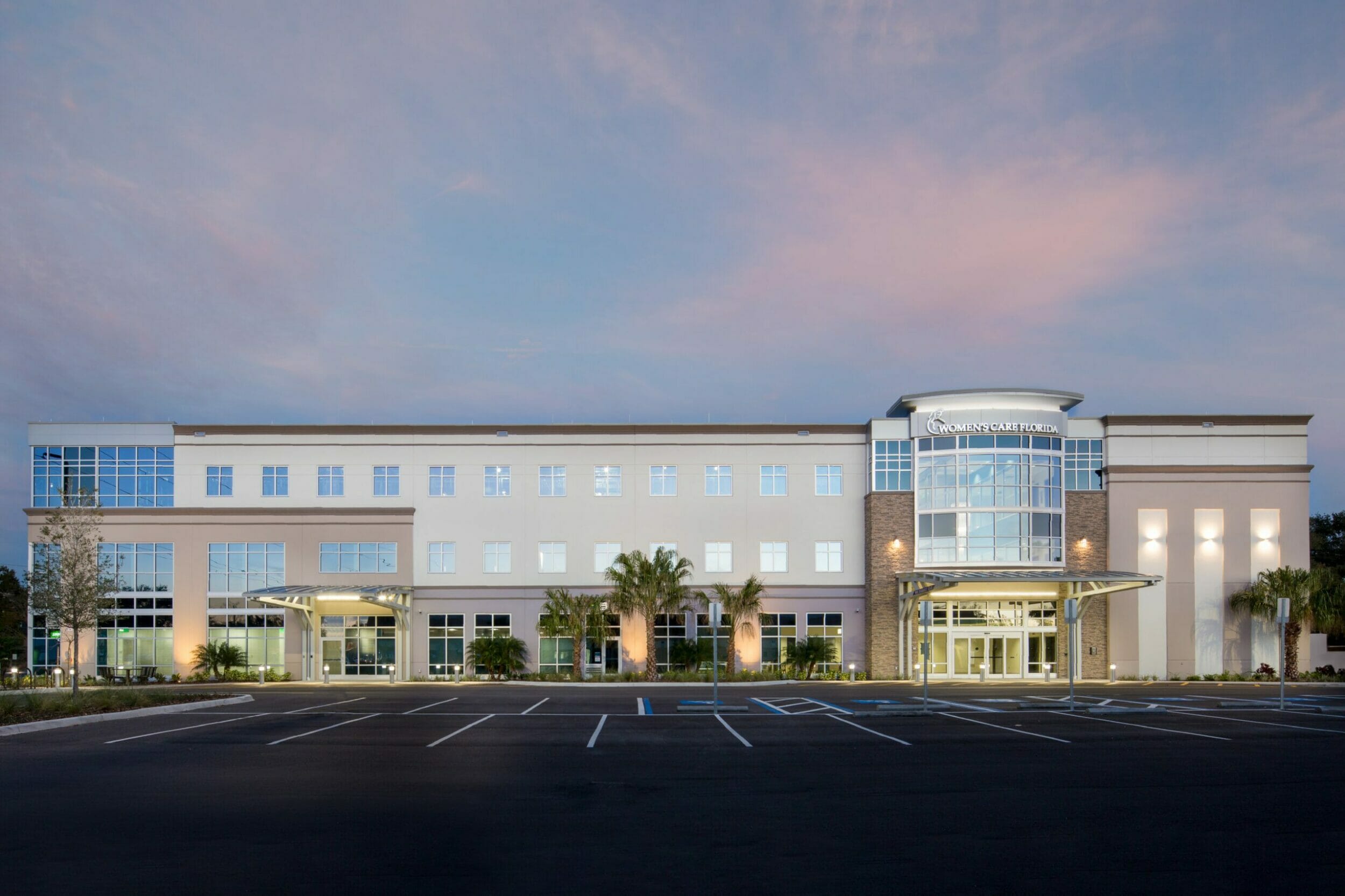 Exterior view Womens Care Florida medical office building, blue sky, clouds, palm trees