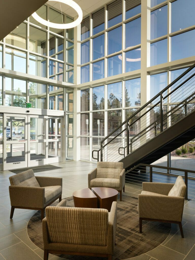 HC Summit lobby with a seating area of four chairs around a small table and a staircase int he background