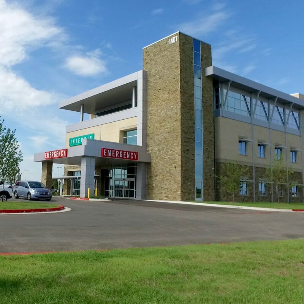 Groud view of Integris OKC West community hospital, the integris sign for where the mergency area and medical offices are is in front with the hospital in the back