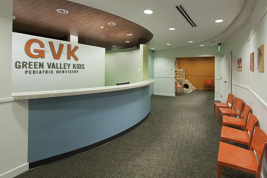 pediatric dentistry reception desk, orange chairs, play area