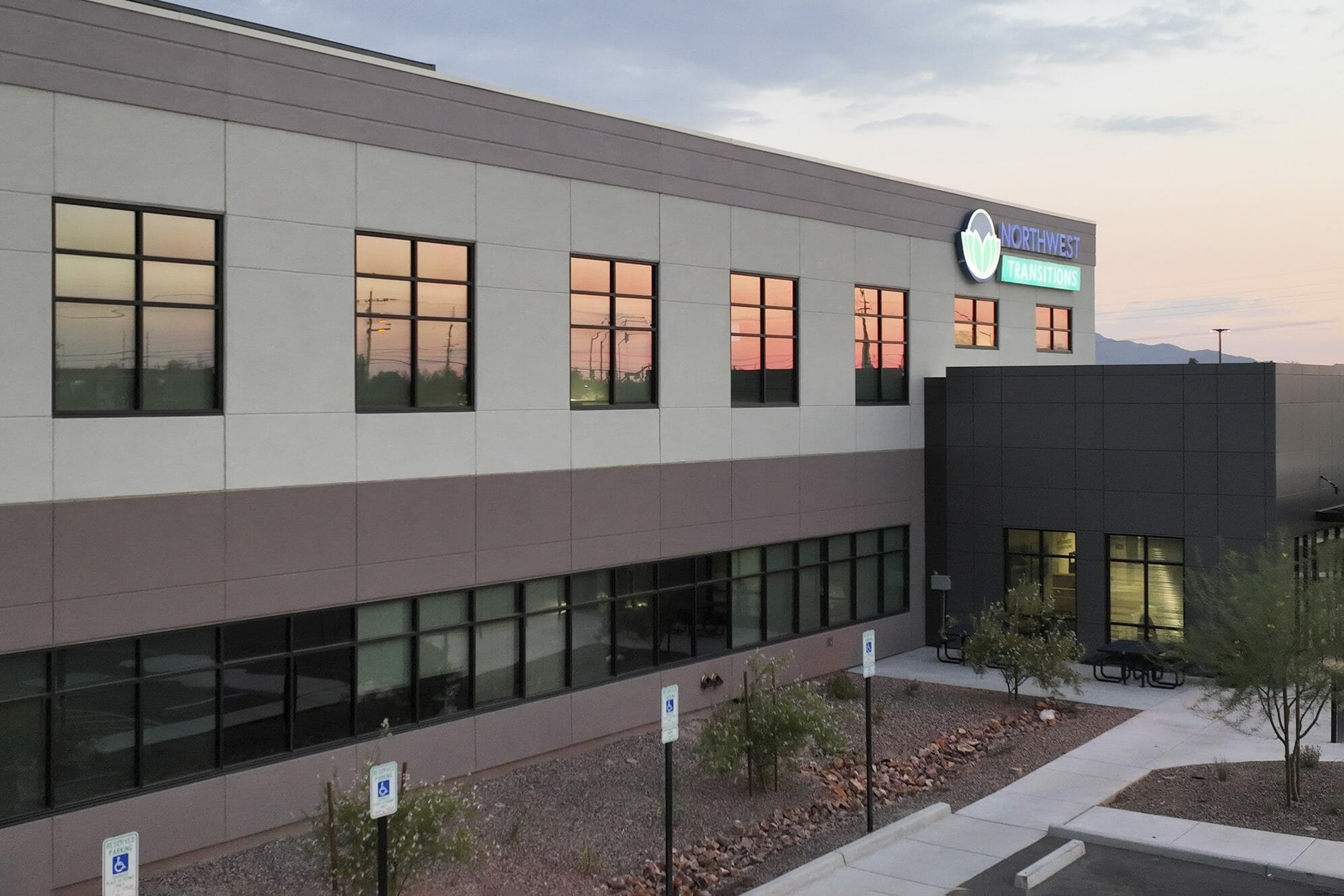 Aerial view of the front of NorthWest Transitions Rehabilitation Hospital with a metal awning and an all gray exterior with black trim