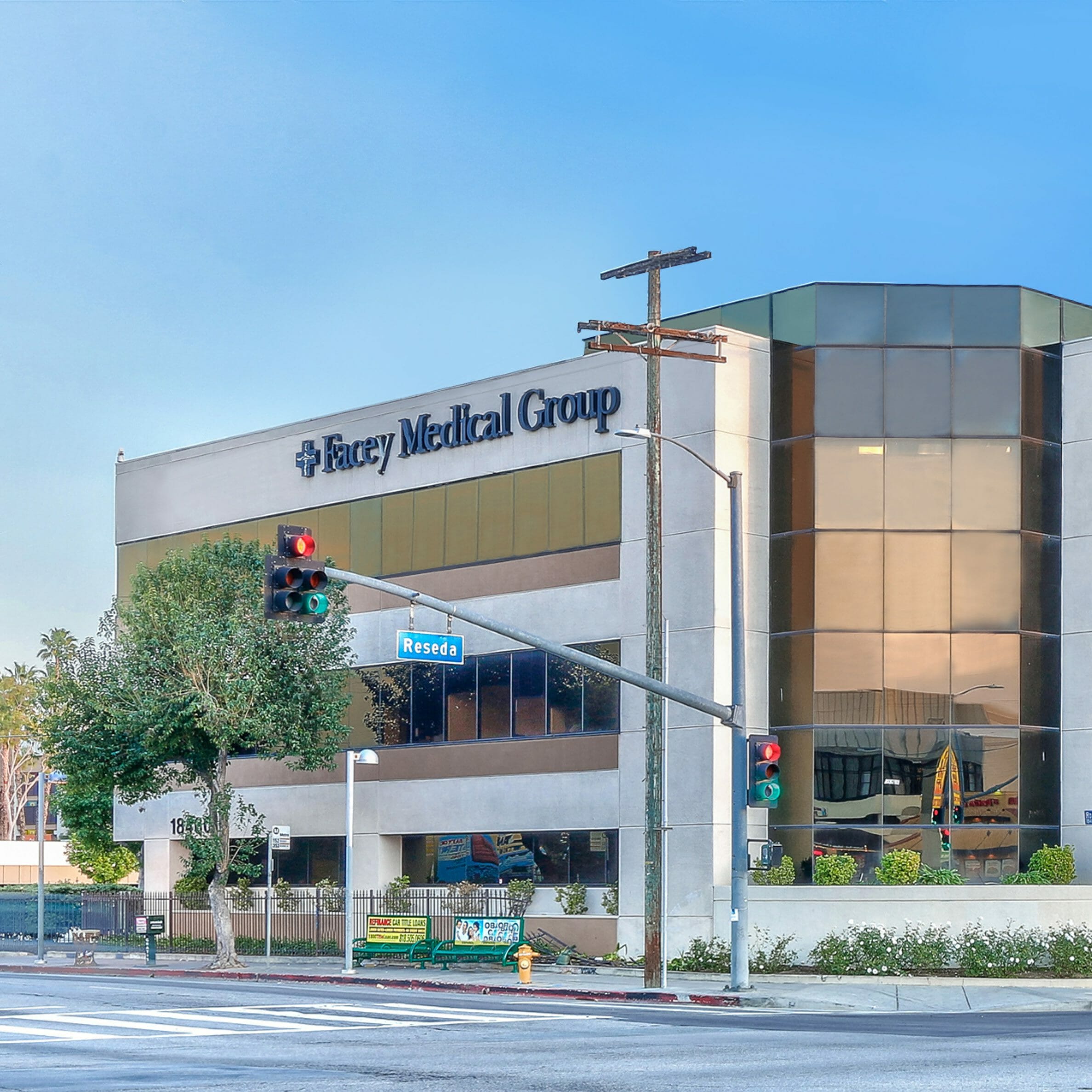 Exterior street view of tan and white, 3-story medical building with a sign for Northbridge Plaza Pharmacy between the first and second floors